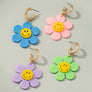 Huggie hoop dangling flower smiley face earrings